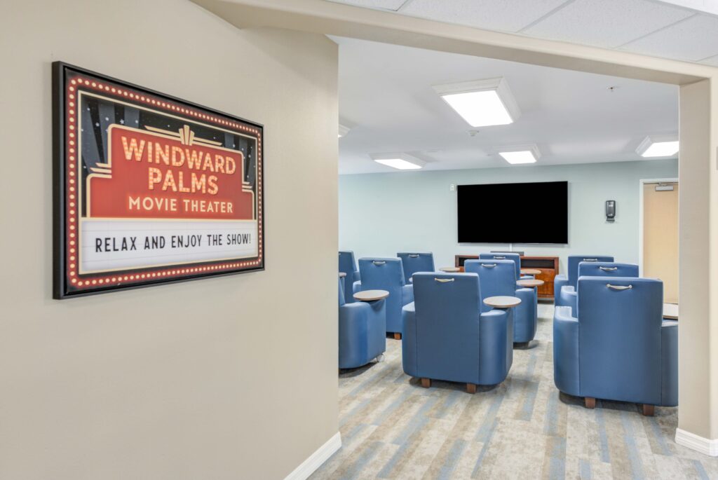 8440-South-Military-Trail-Boynton-Beach-FL-33436-USA_20220810_016 - Windward Palms Interior shot of Windward Palms movie theater room. Comfortable blue chairs are lined up in front of a big television at Windward Palms, a premier senior living community near Boca Raton.