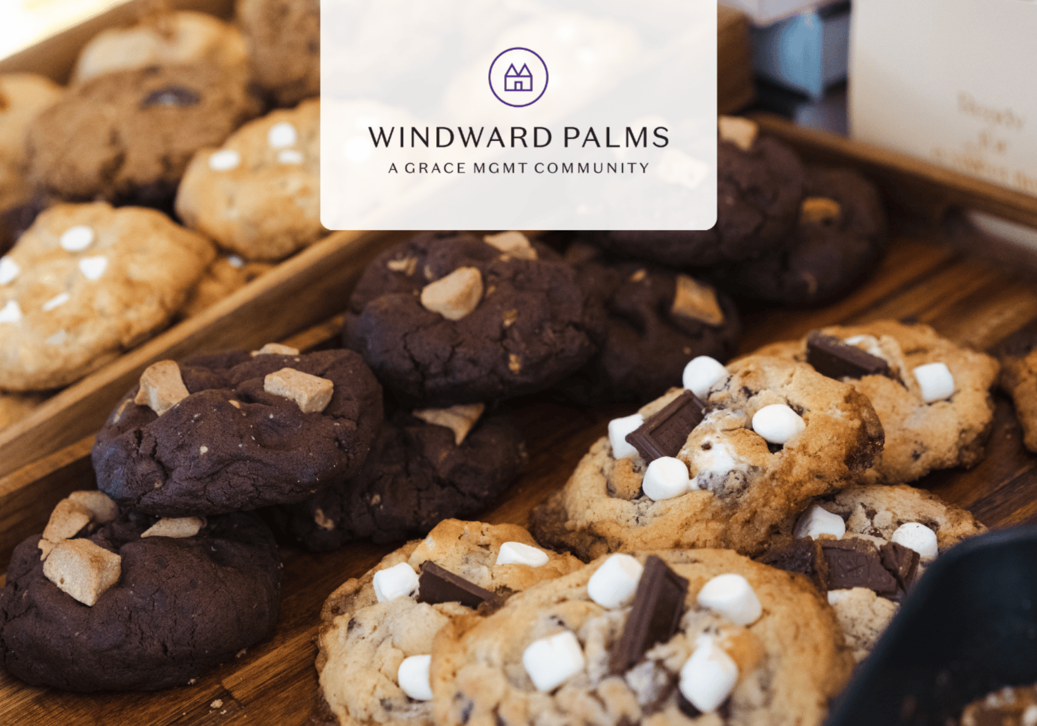 Tray of cookies with chocolate chunks and marshmallows on a wooden surface, Windward Palms branding overlaid